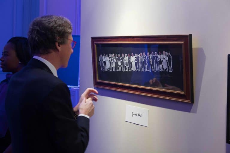 un homme de profil observe un tableau lors d une exposition