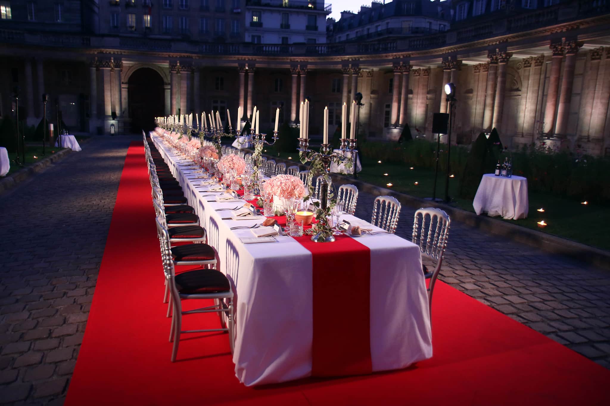 Diner d exception paris luxe chandeliers fleurs table nappe rouge et blanche cour d honneur hotel de soubise paris evenementiel agence WATO paris