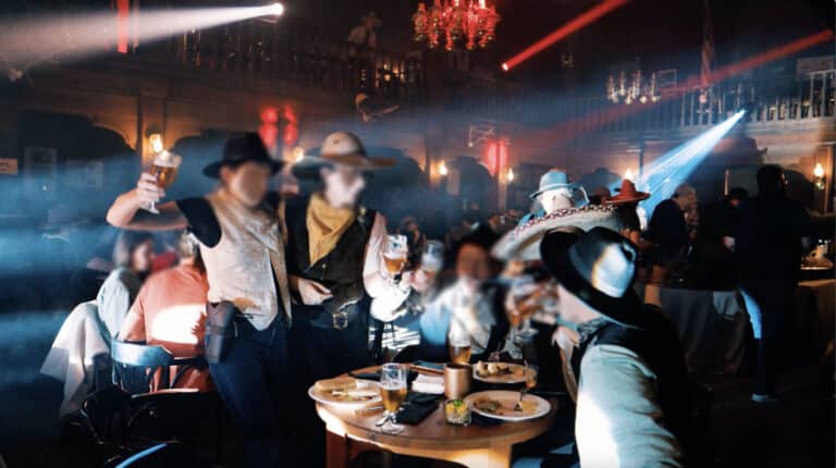 photo de groupe a table diner immersif western soir dans saloon Seminaire voyage immersif agence evenementiel paris WATO