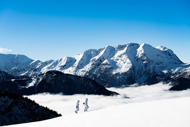 Paysage Montagne de jour avec commandos alpins marchant vers le sommet au dessus de mer de nuages Seminaire immersif montagne voyage prive Alpe Huez Agence Evenementiel Paris WATO
