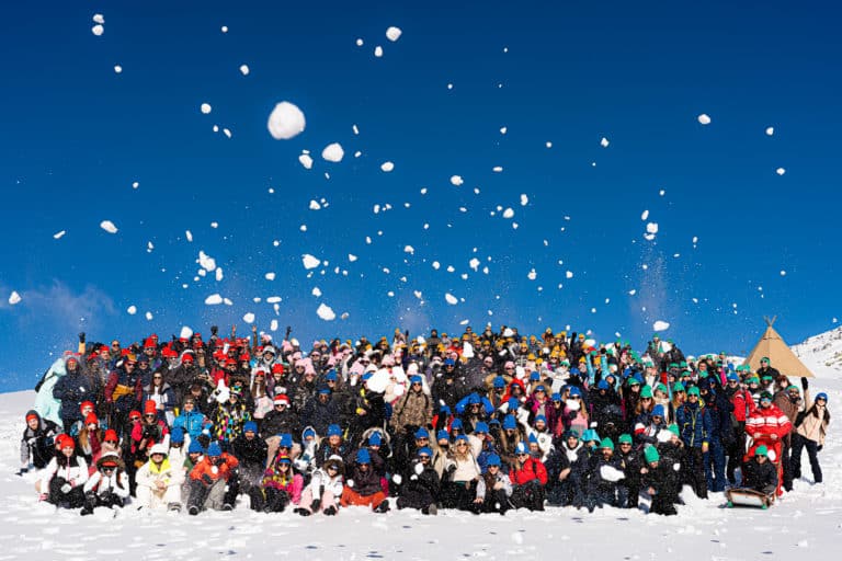 Photo de groupe de jour au sommet de la montagne Seminaire immersif voyage prive Alpe Huez Agence Evenementiel Paris WATO