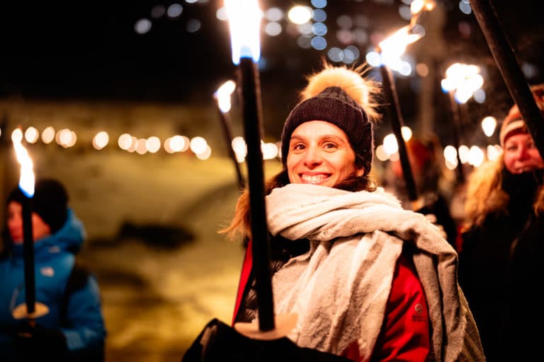 Portrait Femme avec torche enflammee de nuit Seminaire immersif montagne voyage prive Alpe Huez Agence Evenementiel Paris WATO