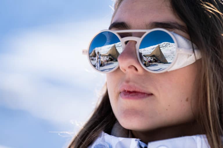 Portrait femme reflet montagne dans lunettes Seminaire immersif montagne voyage prive Alpe Huez Agence Evenementiel Paris WATO