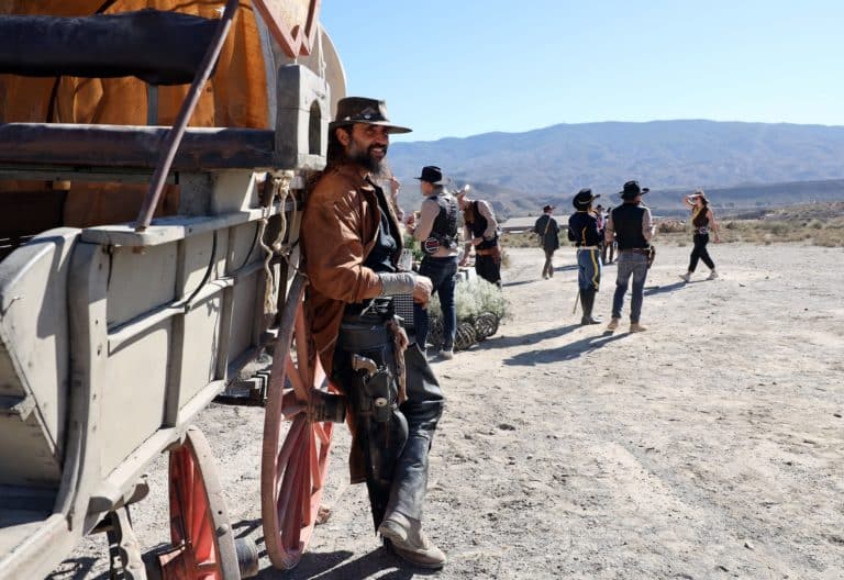 portrait acteur cowboy adosse diligence dans camp milieu du desert jour Seminaire immersif western voyage Agence evenementiel Paris WATO